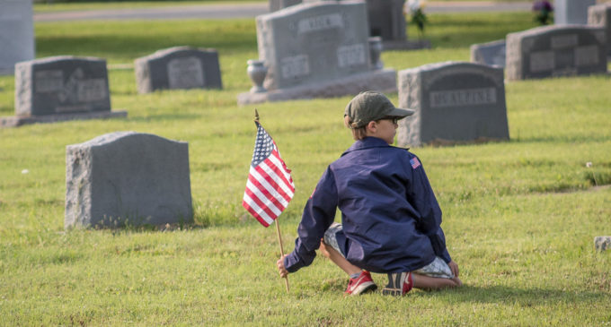 Local scouts honor veterans with flags in cemetery
