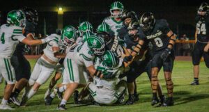 Buckaroo defensive players tackling a Commanche player.